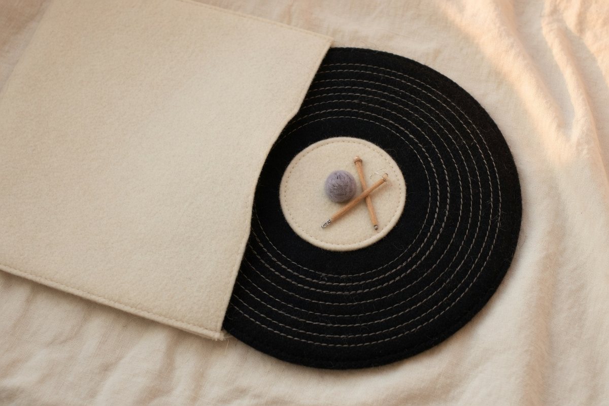 A felt record sliding out of a plain felt sleeve